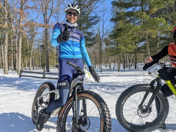 A racer at Huma Loopa Licious smiles on a snowy day on his bike.